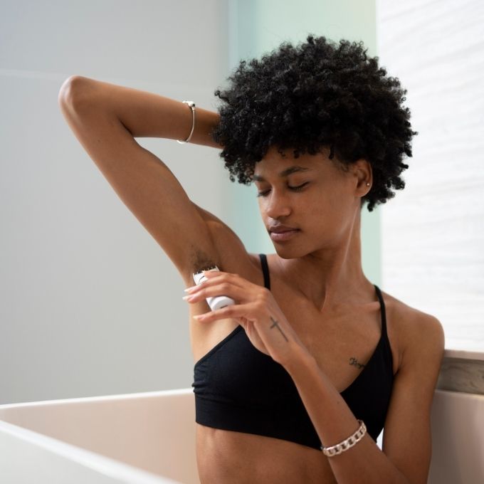Customer applying Bushbalm to her underarm by the bath