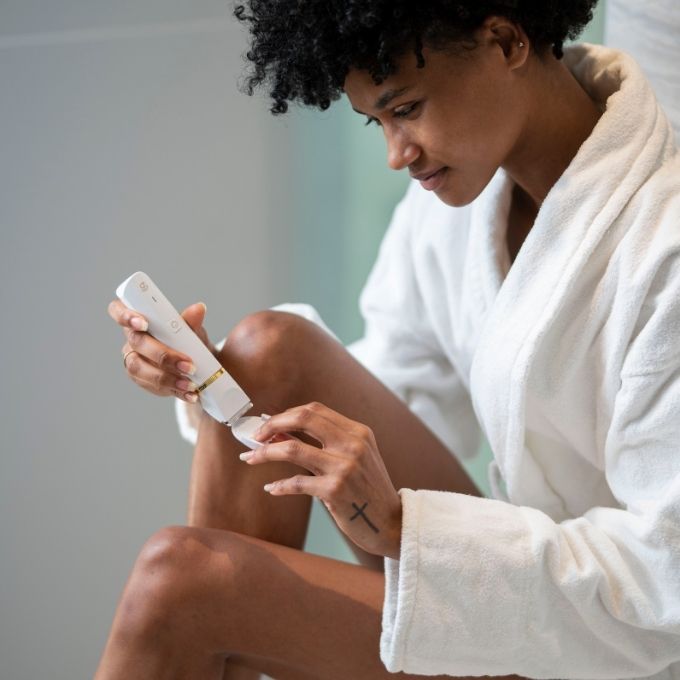 Customer in a robe applying Bushbalm to her leg