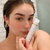 Woman holding bikini line trimmer in shower