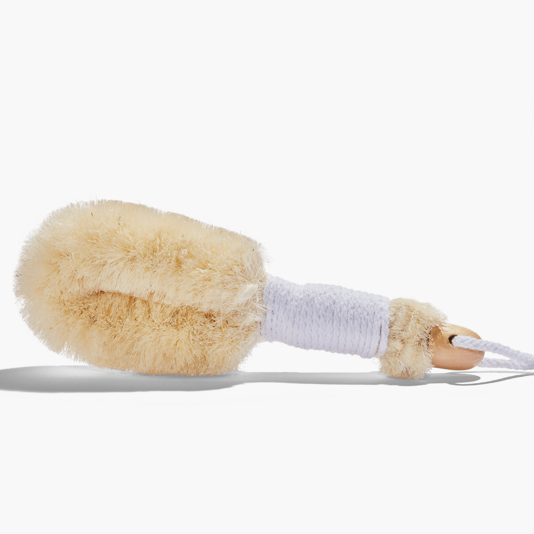 Wooden-handled body brush with light-colored bristles and a white rope loop.