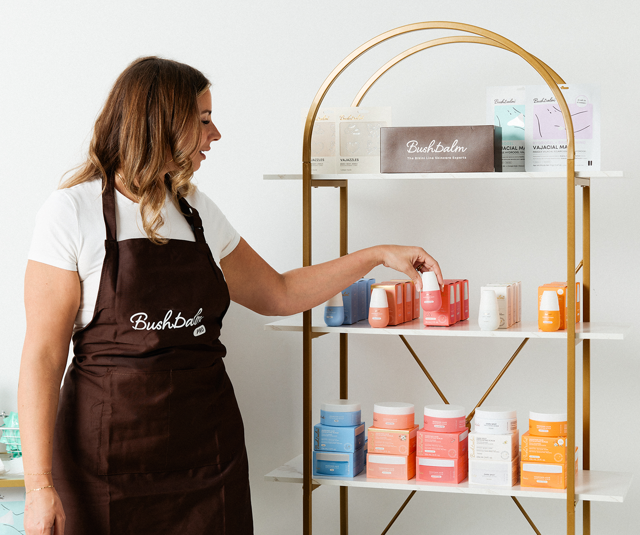 An esthetician arranging Bushbalm products on a retail shelf